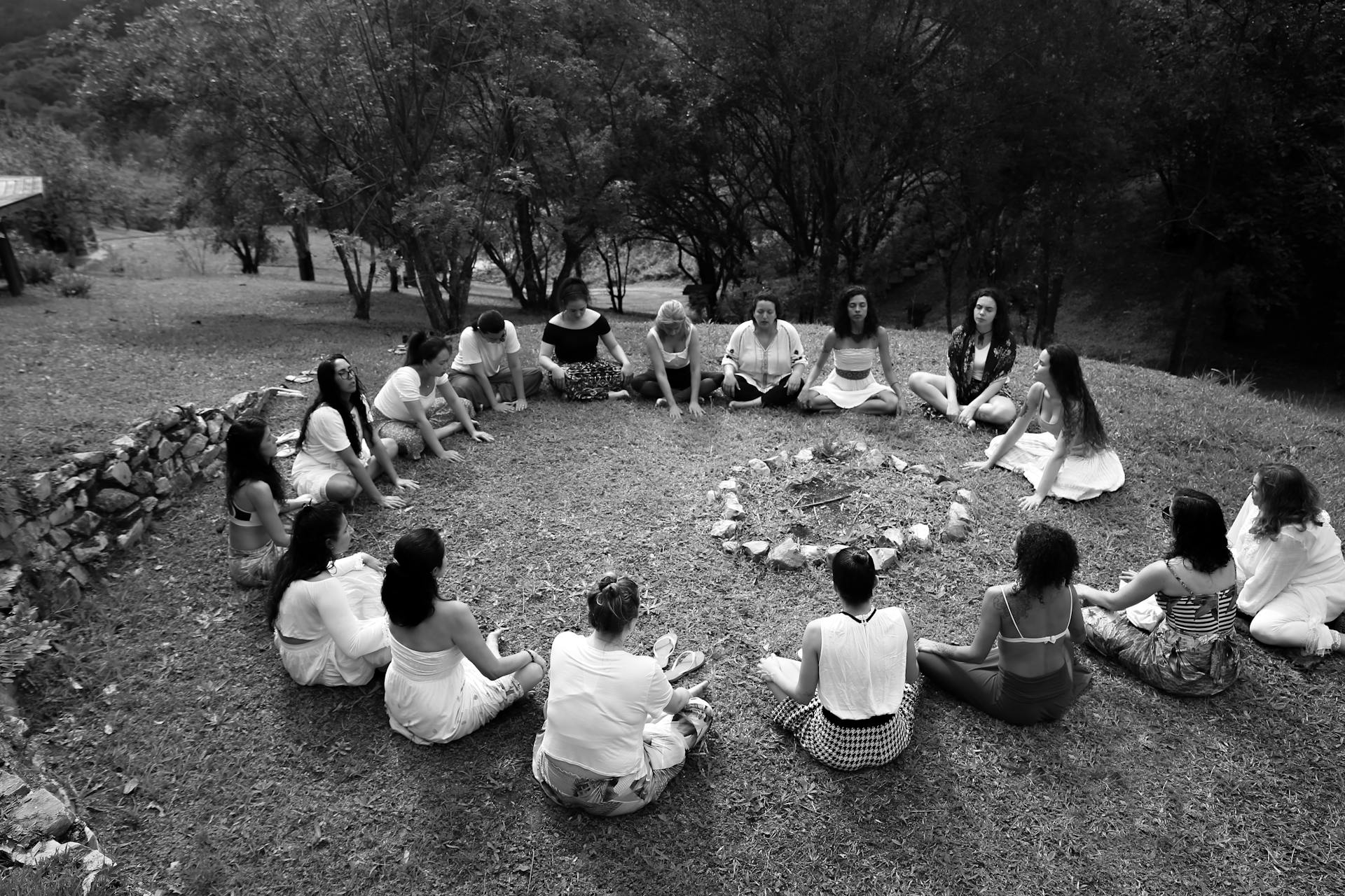 Women gathered in a circle around a fire